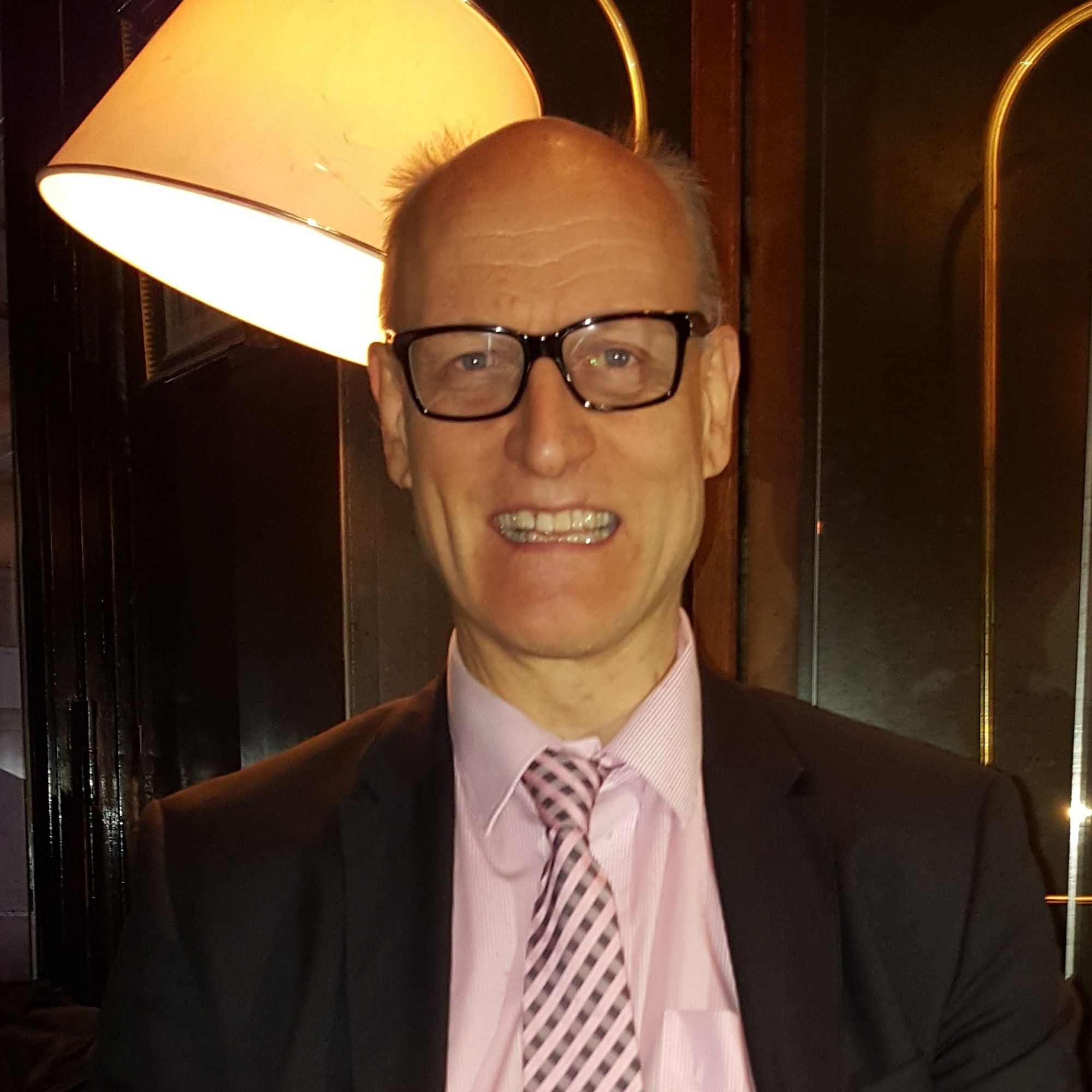 three men laughing while looking in the laptop inside room